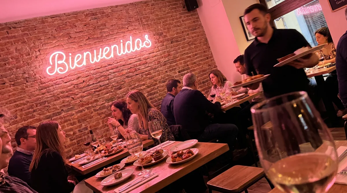 Rótulo de neón LED rosa con la palabra Bienvenidos en el interior de un restaurante español